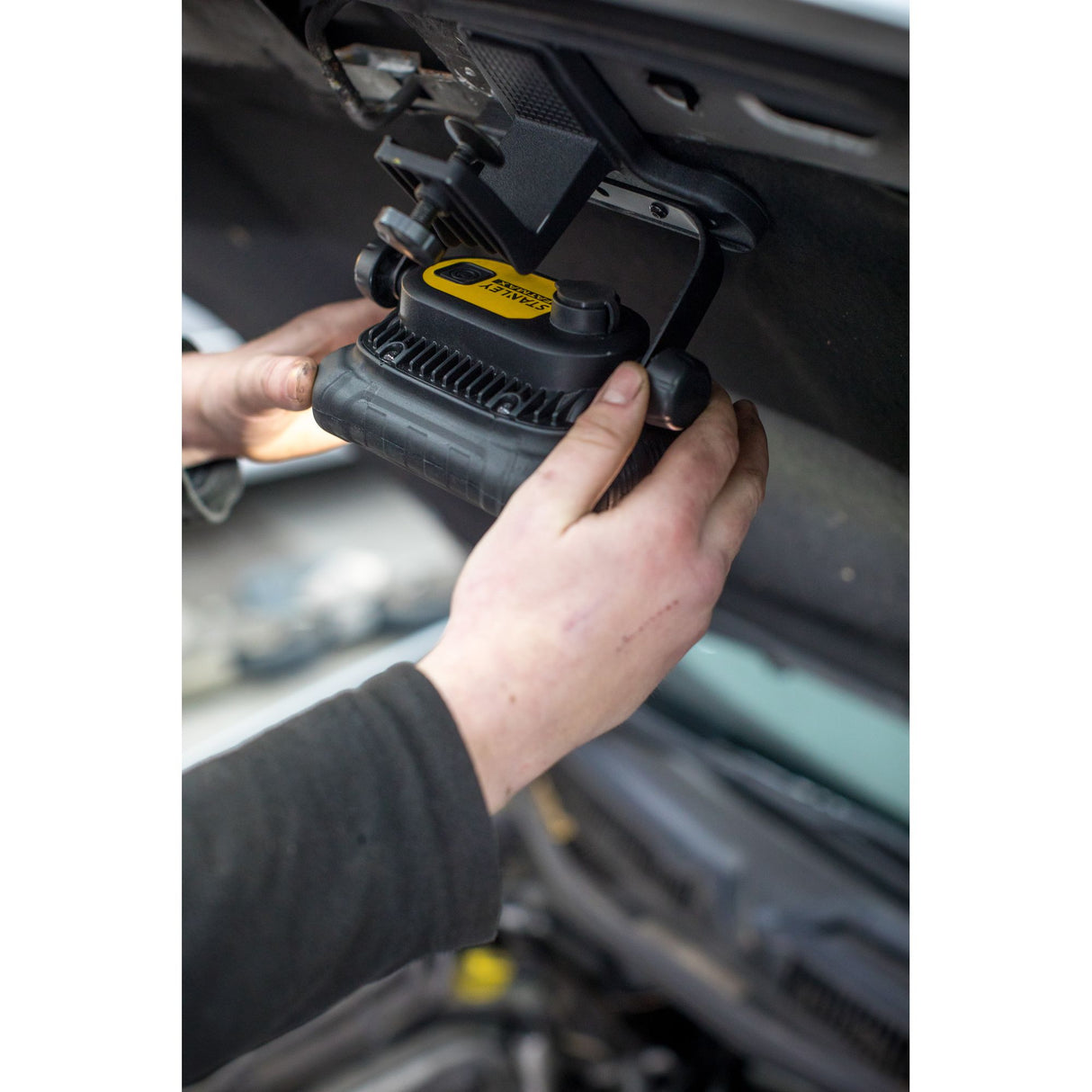 Lampe de travail Stanley, projecteur LED jaune et noir utilisé sous un capot de voiture