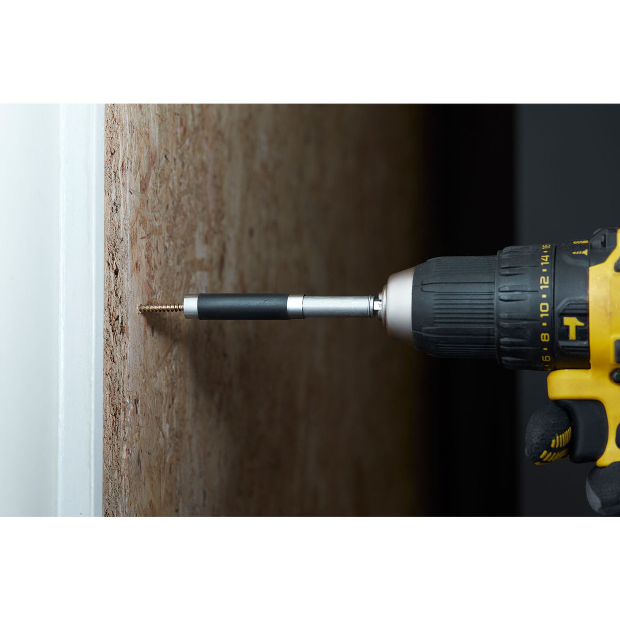 Embout de vissage Stanley pour perceuse, noir et argent, en action sur une vis dans du bois