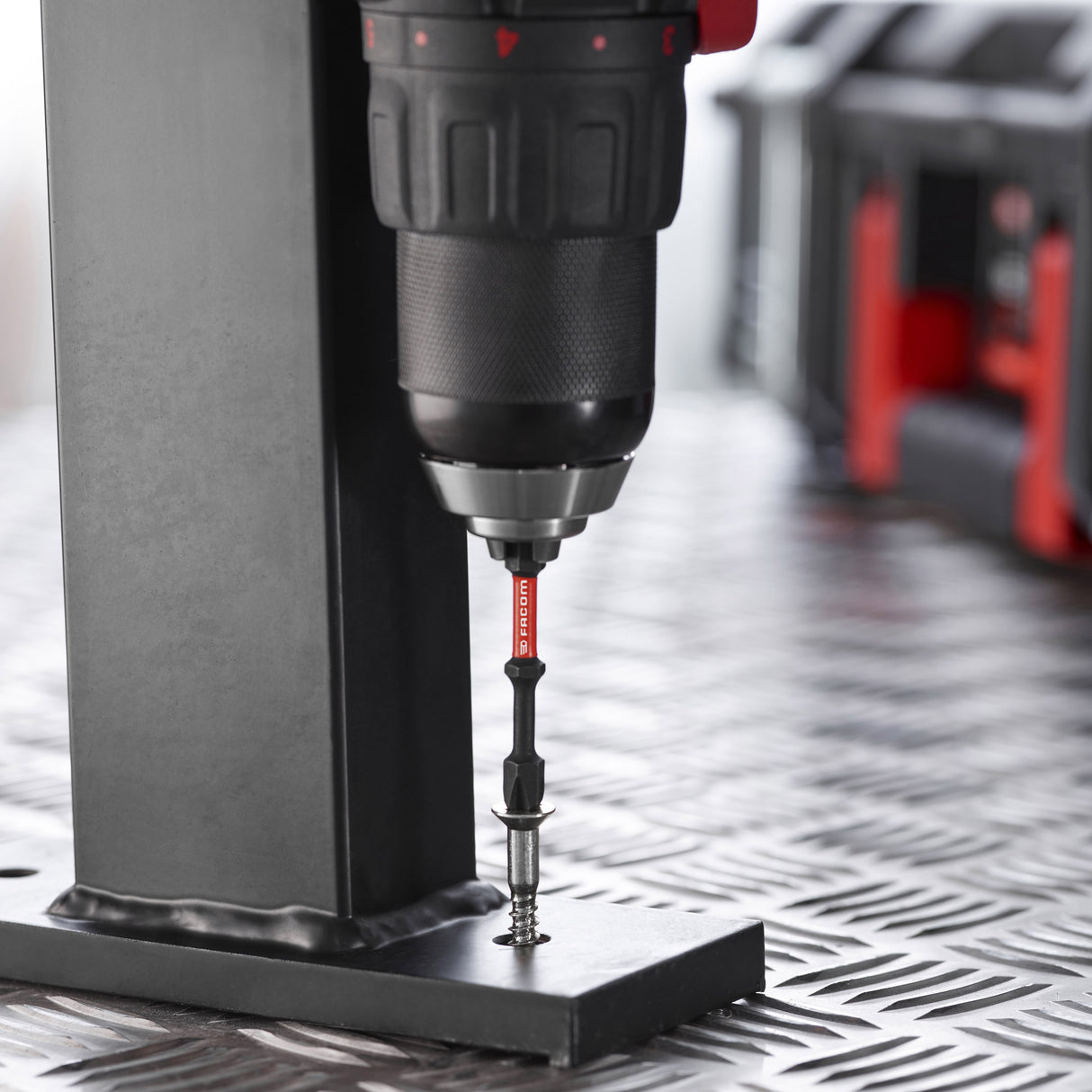 Embout de vissage Facom, accessoire d’outillage noir et rouge en action sur perceuse