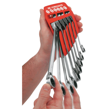 Jeu de clés à cliquet Facom, outil de couleur argent et rouge, tenu en main.