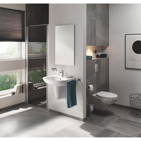 Salle de bain moderne avec lavabo suspendu Grohe, couleur blanche, accessoires chromés.