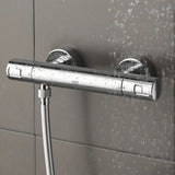 Mitigeur thermostatique de douche Grohe, couleur chromée, installé sur carrelage gris.