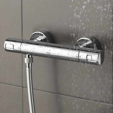 Mitigeur thermostatique de douche Grohe, couleur chromée, installé sur carrelage gris.