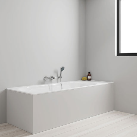 Baignoire Grohe blanche rectangulaire avec mitigeur mural, salle de bain moderne lumineuse