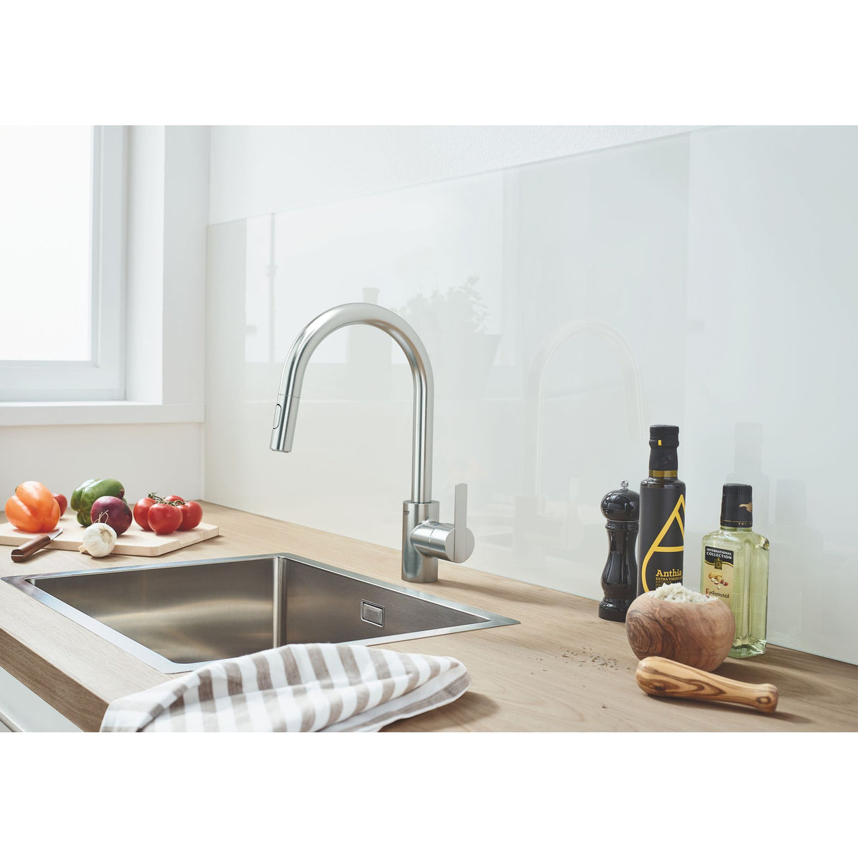 Mitigeur de cuisine Grohe, robinet en acier inoxydable, couleur argent, sur plan de travail bois.