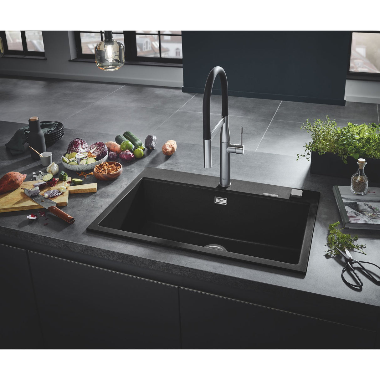 Évier de cuisine noir Grohe avec robinet moderne, plan de travail gris, légumes frais