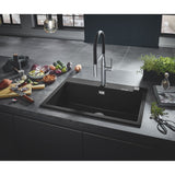 Évier de cuisine noir Grohe avec robinet moderne, plan de travail gris, légumes frais