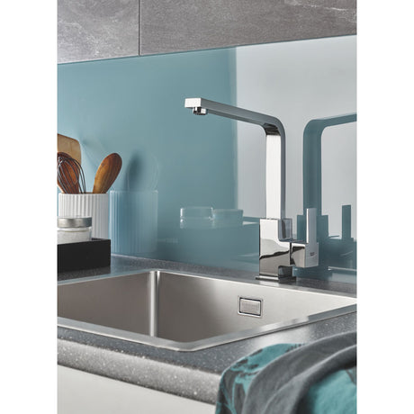 Mitigeur de cuisine Grohe chromé, robinet moderne gris argent au-dessus d’un évier inox.