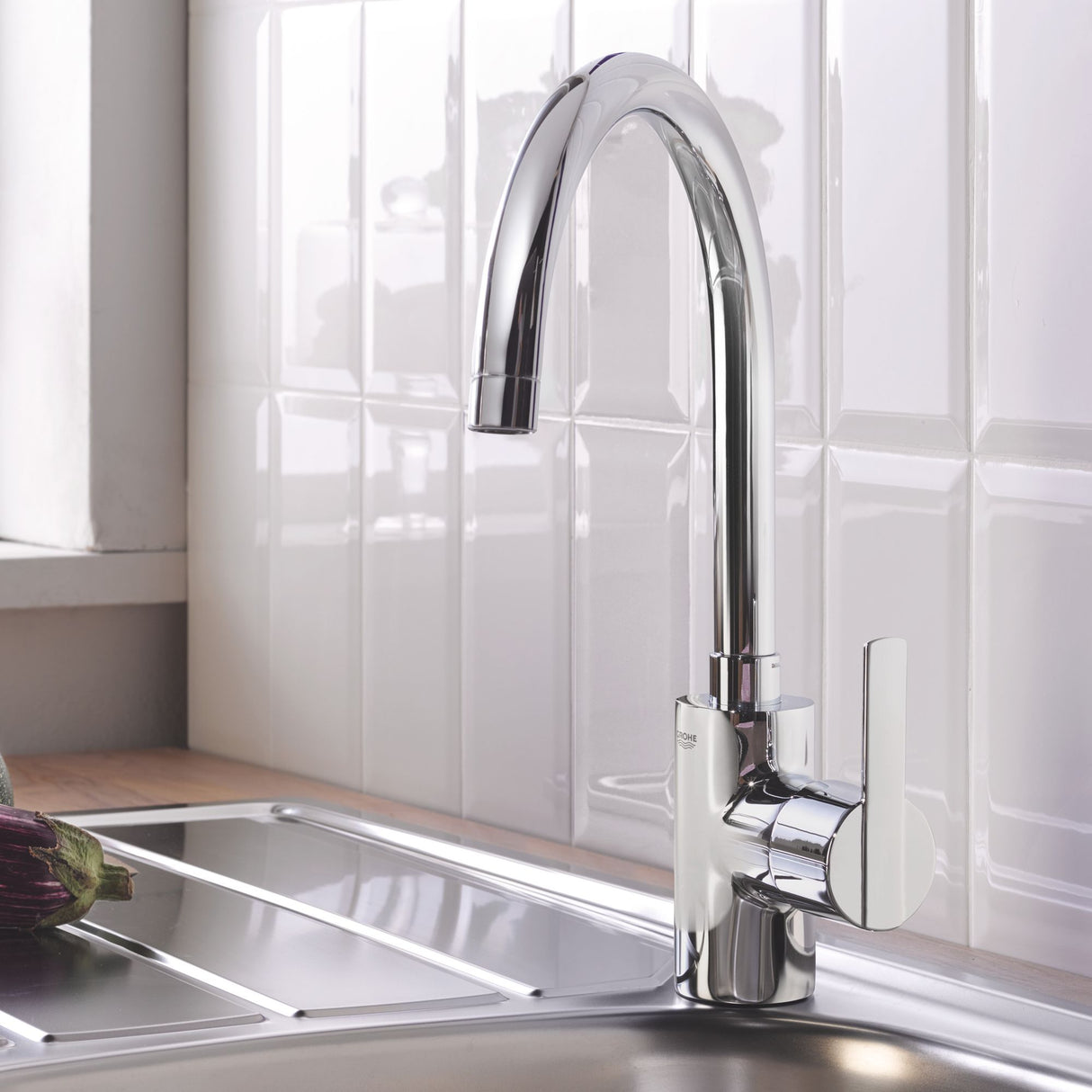 Mitigeur cuisine Grohe chromé, robinet moderne couleur argent installée sur évier.