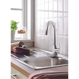 Mitigeur de cuisine chromé Grohe, robinet moderne couleur argent sur évier inox.