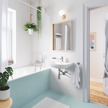 Salle de bain moderne avec baignoire Grohe, carrelage bleu clair, robinetterie chromée.