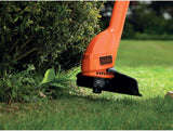 Coupe-bordures BLACK+DECKER, outil de jardinage orange, usage sur pelouse.