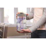 Réservoir transparent pour aspirateur Bissell, couleur gris et violet, tenu en main.