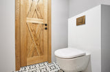 Toilette suspendue VIPANEL, blanc, avec plaque de commande bois, carrelage motif géométrique.